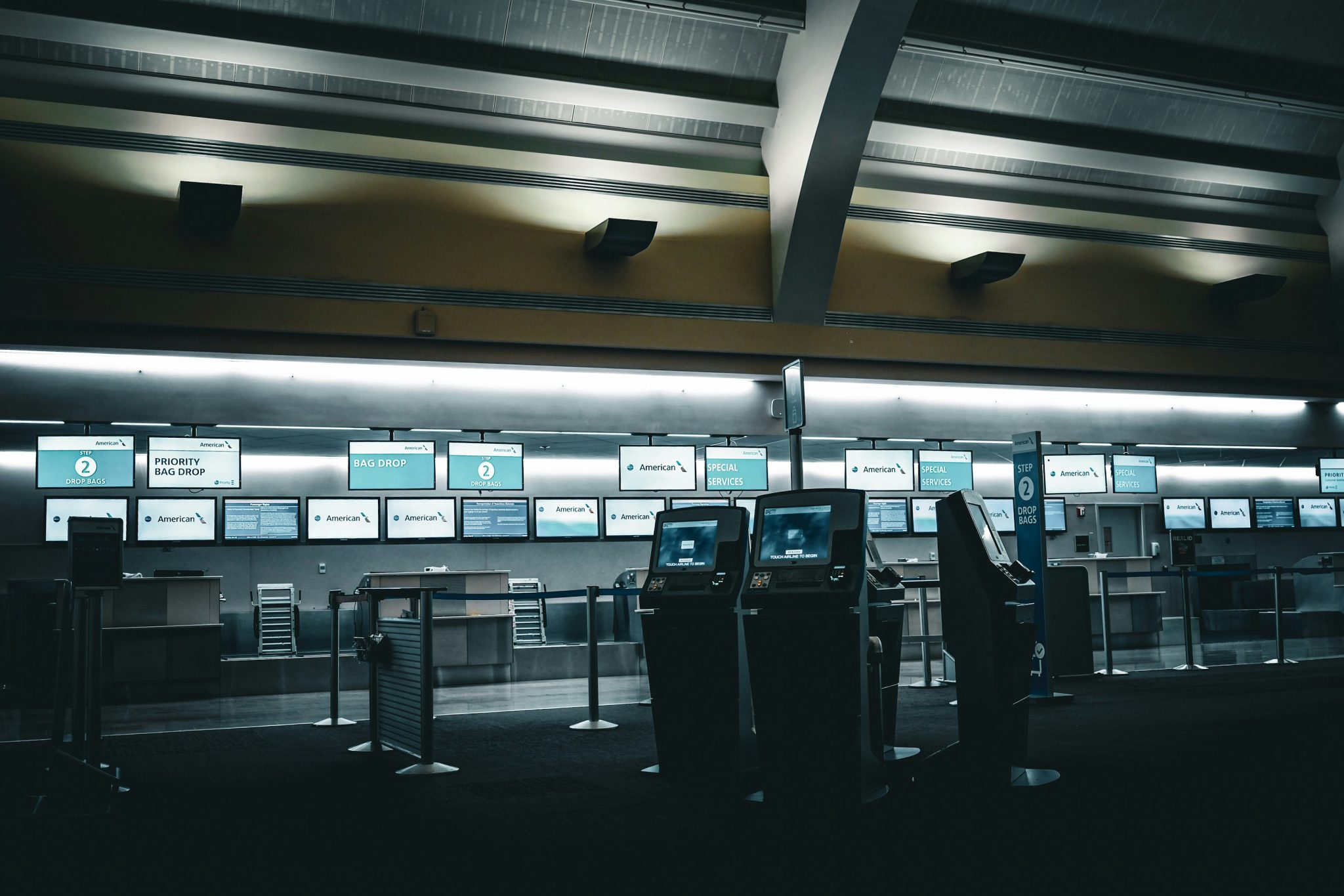 Empty airport check-in counters with glowing screens