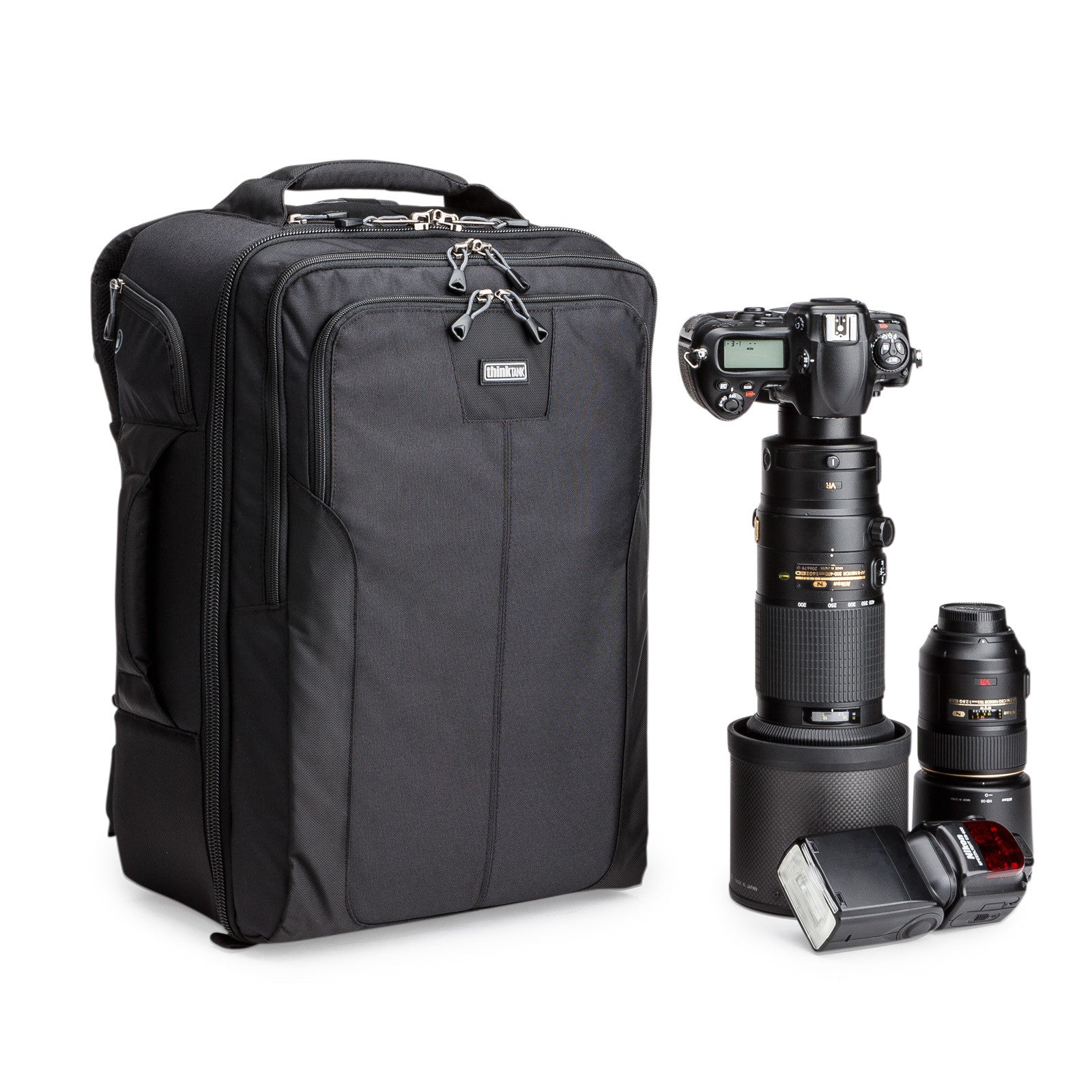Think Tank Airport Accelerator camera backpack in black, front view with a camera and telephoto lens beside it